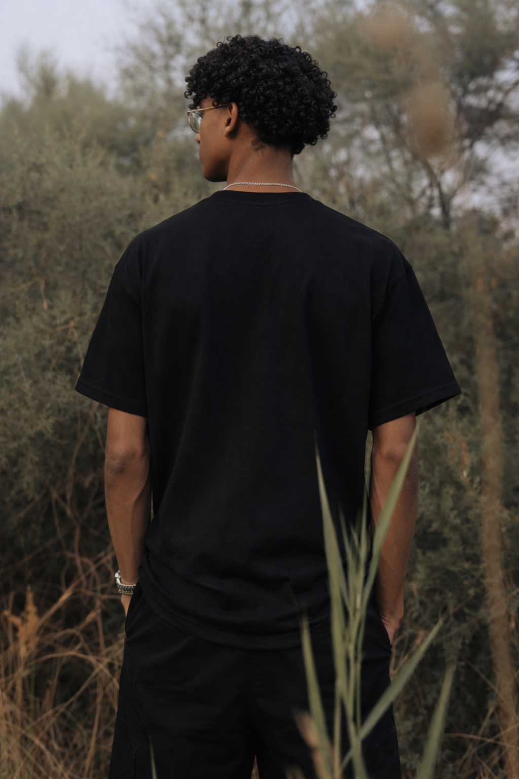 Achterkant van een zwart oversized T-shirt van OWN LANE.